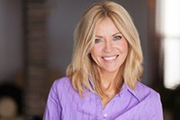 Blonde woman in purple shirt smiling