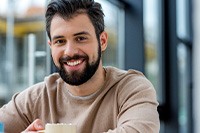 Man holding mug of hot chocolate and smiling