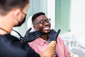 Dentist looking at smiling patient's teeth